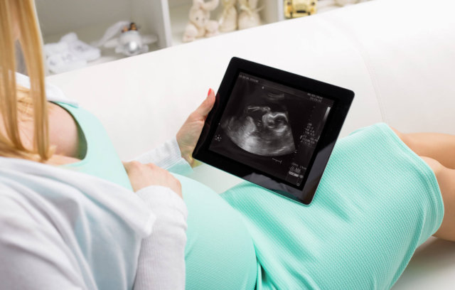 Беременная женщина просматривает результаты УЗИ